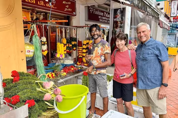Visitors enjoy vibrant flower garlands at a bustling market in Singapore's cultural street food tour.