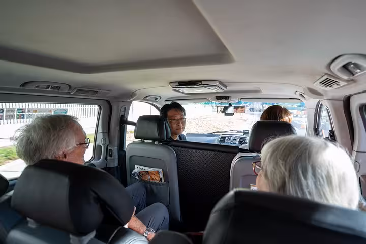 Travelers in a comfortable van explore Singapore's cultural and culinary landmarks on a guided tour.