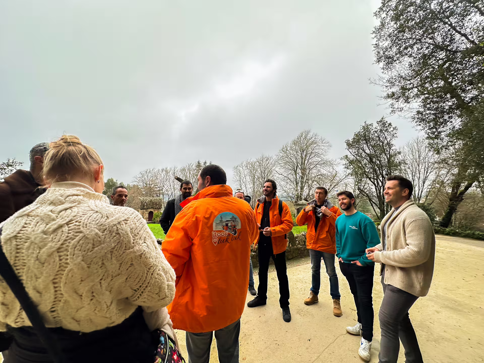 Tour group gathering at a scenic spot in Sintra, Portugal, led by guides in orange jackets during a private van tour.