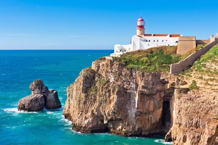 Majestic lighthouse perched on rugged cliffs overlooking the Atlantic Ocean, featured on a Sintra, Cascais & Estoril tour.