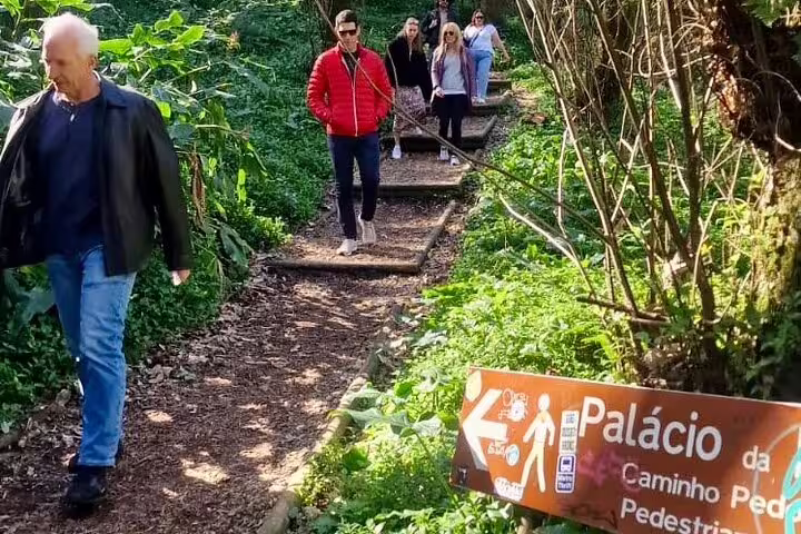 Tour group explores scenic forest trail in Sintra, Portugal, during private tour with wine tasting, highlighting hidden gems.