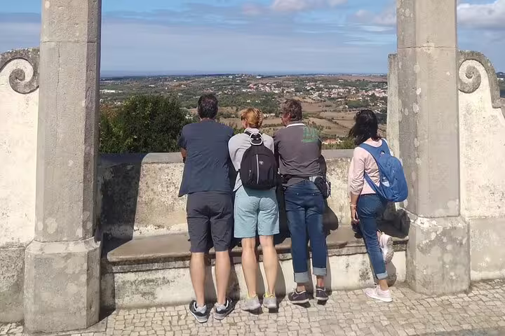 Tourists enjoying a scenic lookout over the expansive landscape of Sintra and Cascais.