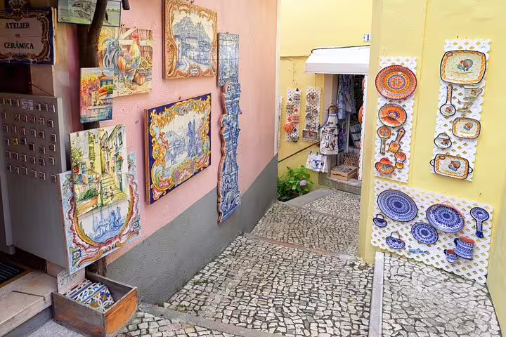 Charming alley in Sintra with colorful ceramic art displays, perfect for exploring hidden gems on a private tour with wine tasting.