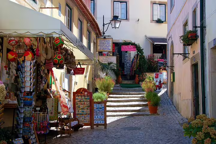 Quaint Sintra street with vibrant shops and cobblestone path, a highlight on Lisbon guided day tour.