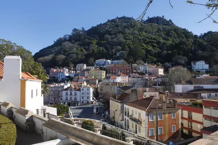 Scenic view of Sintra's colorful townhouses nestled against lush hills, ideal for exploring on a private tour from Lisbon.