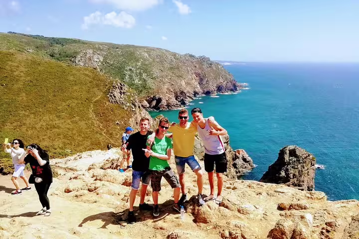 Tourists enjoying the stunning coastal views at Cabo da Roca during the Sintra & Dream Villages Tour in Portugal.