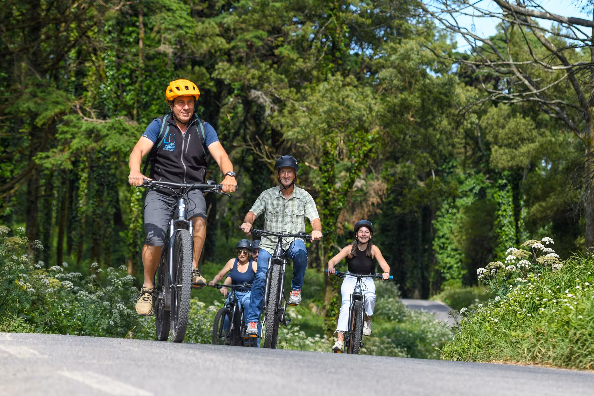 Riders on Sintra e-bike tour relishing a vibrant woodland adventure, highlighting Portugal's natural beauty.