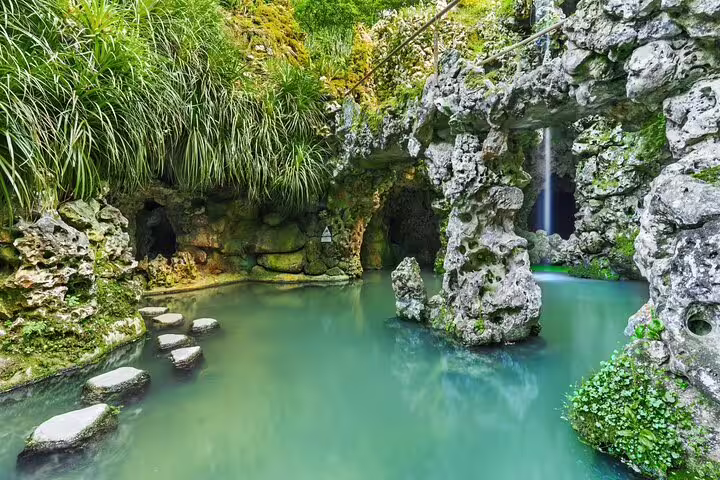 Enchanting grotto with stepping stones and lush greenery in Sintra, explored on a private tour with wine tasting experience.