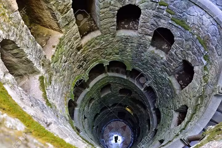 The mystical Initiation Well at Quinta da Regaleira, Sintra, with its spiraling stone staircase and mysterious allure.