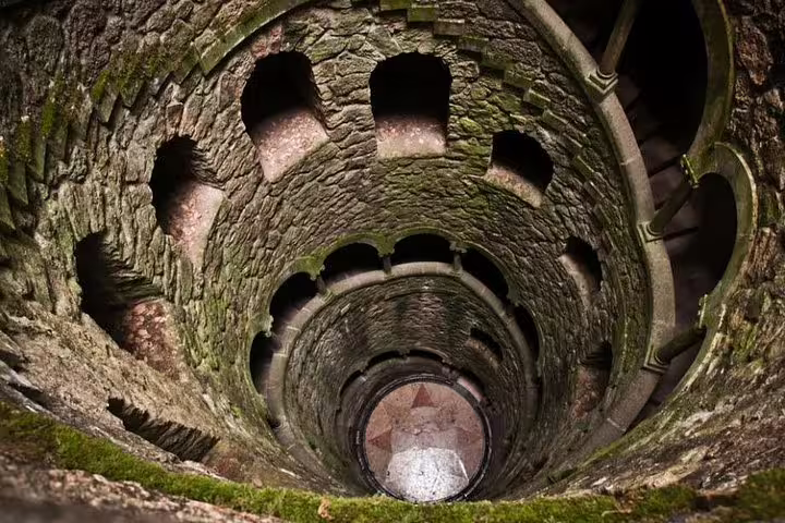 Ancient stone spiral staircase of the Initiation Well in Sintra, Portugal, showcasing mystical architecture on a half-day tour.