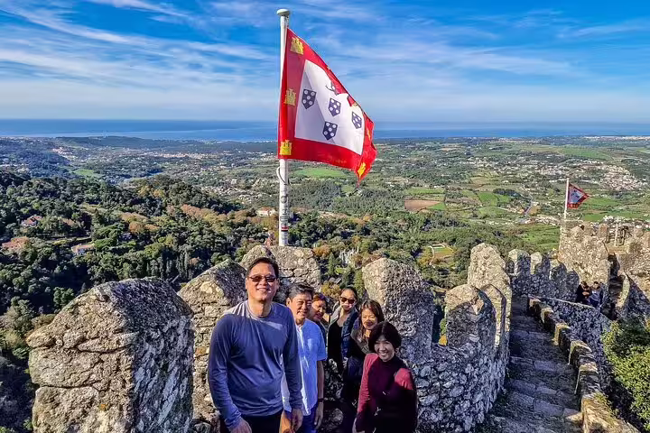 Tourists enjoy breathtaking views from the historic walls of Sintra's Moorish Castle during a private tour from Lisbon.