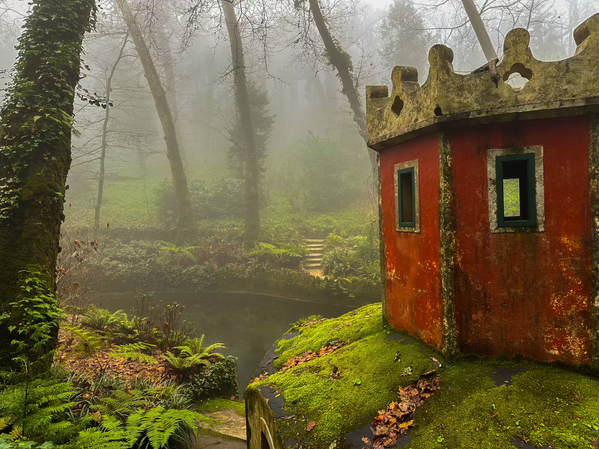 Moss-covered red turret amidst lush greenery in Sintra's mystical forest, perfect for an enchanting private tour experience.