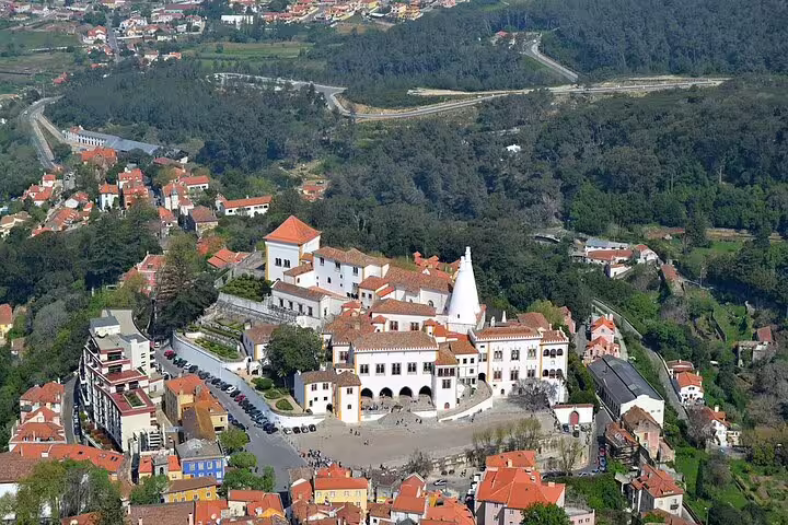 Aerial view of the historic Sintra National Palace surrounded by lush landscapes, perfect for a cultural food tour.