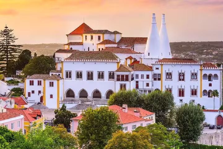 Stunning view of Sintra National Palace at sunset, a highlight of the Lisbon to Sintra, Cabo da Roca, and Cascais tour.