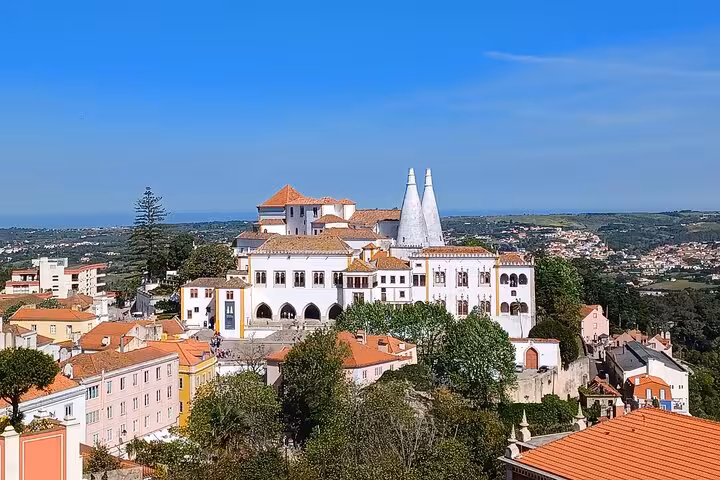 Sintra National Palace panoramic view from tuk tuk tour, historic center rooftops and coastal horizon