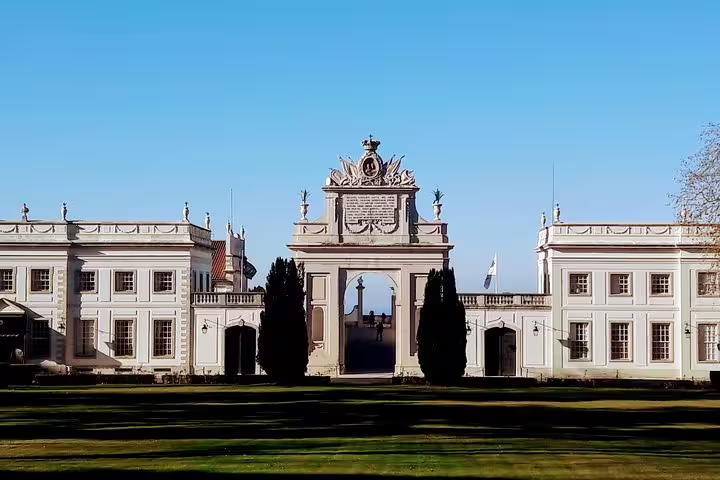 Elegant palace facade with intricate archway under clear blue sky, featured in Sintra World Heritage and Cascais luxury tour.