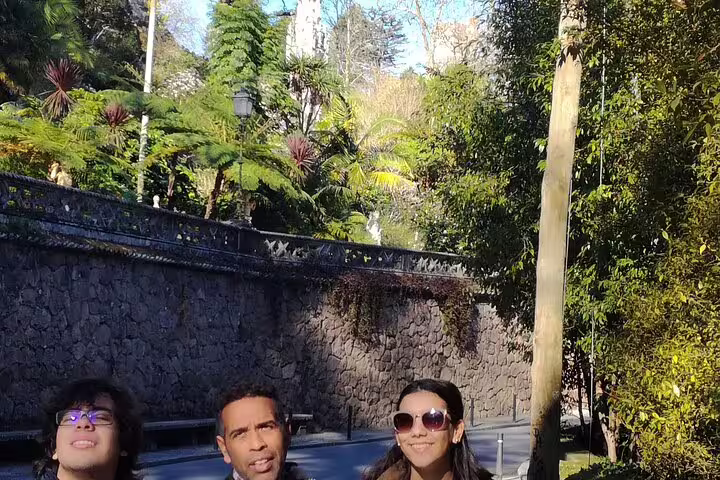 Travelers exploring lush gardens with historic architecture in Sintra during private tour from Lisbon.