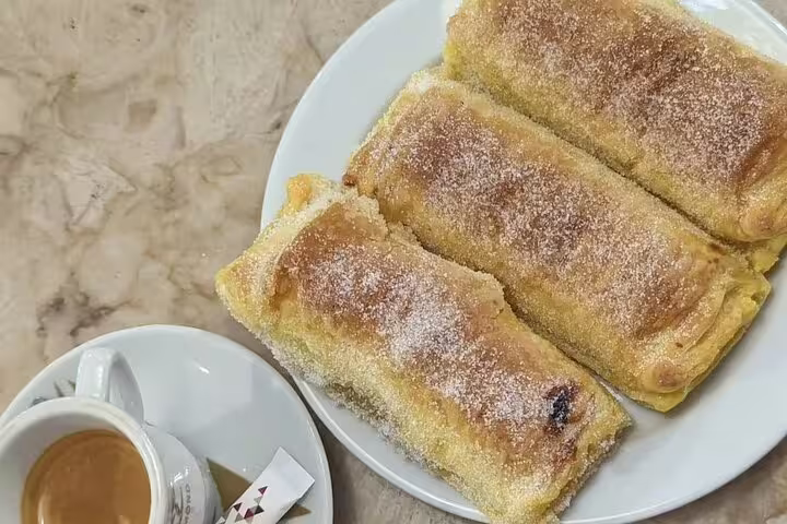 Delicious Sintra pastries with a dusting of sugar, served alongside a rich espresso, enhancing your guided tour experience.