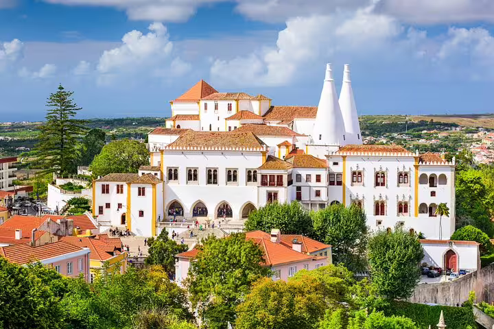 Aerial view of the stunning National Palace of Sintra, surrounded by lush greenery, featured in the Sintra day tour package.
