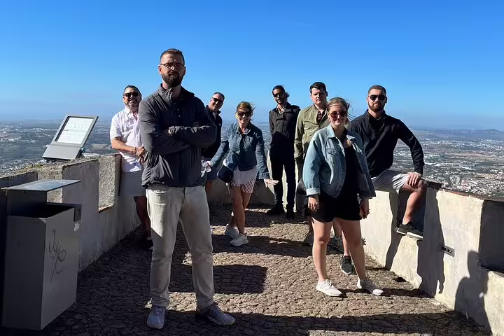 Group enjoying panoramic views on Sintra, Pena Palace, Cabo da Roca, Cascais day trip from Lisbon under clear blue skies.