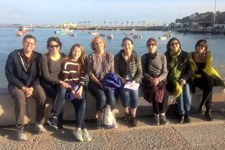 Group enjoying scenic views of Cascais waterfront during Sintra, Pena Palace, and Cascais full-day tour from Lisbon.