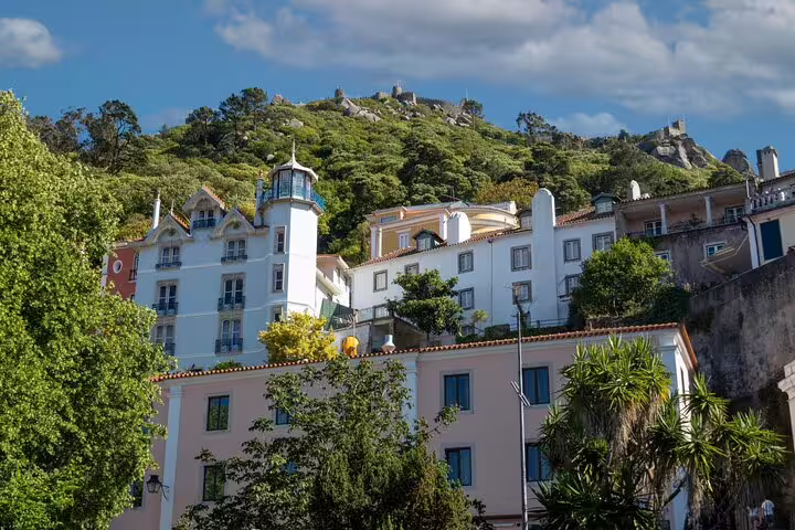 Scenic view of colorful buildings in Sintra with lush hills, perfect for exploring on a full-day tour from Lisbon to Pena Palace and Cascais.