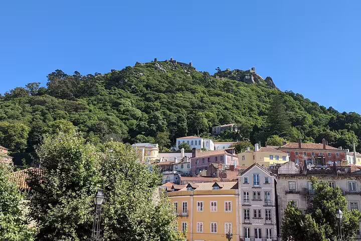 Happy tourists enjoy a lively van ride during the Sintra, Pena Palace, and Cascais full-day tour from Lisbon.