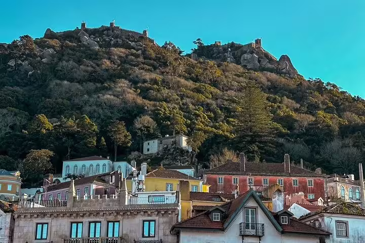Colorful hillside village in Sintra, Portugal, beneath lush greenery, perfect for exploring on a small-group Pena Palace tour.