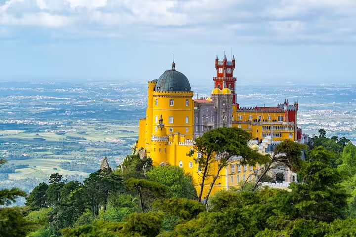 Explore the vibrant Pena Palace in Sintra, a highlight of your food tour with panoramic views and wine tasting.