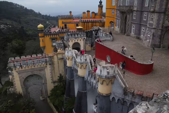 Vibrant view of Sintra's colorful Pena Palace, a must-see on the Lisbon day trip to Cabo da Roca and Cascais.