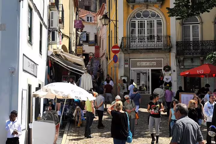 Bustling narrow street in Sintra with tourists exploring shops and cafes, perfect for a Lisbon to Pena Palace and Cascais tour.