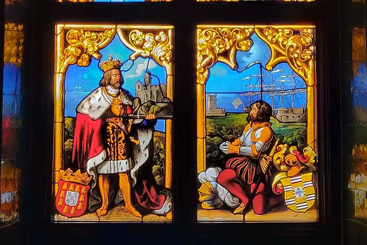 Intricate stained glass window depicting historical figures and maritime scenes in Sintra's palace interior.