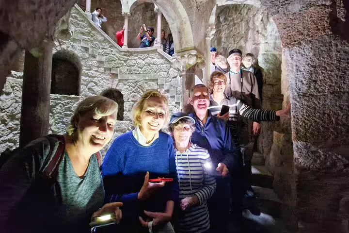 Group exploring Sintra's historic stone architecture on a private tour from Lisbon with tickets to iconic monuments included.