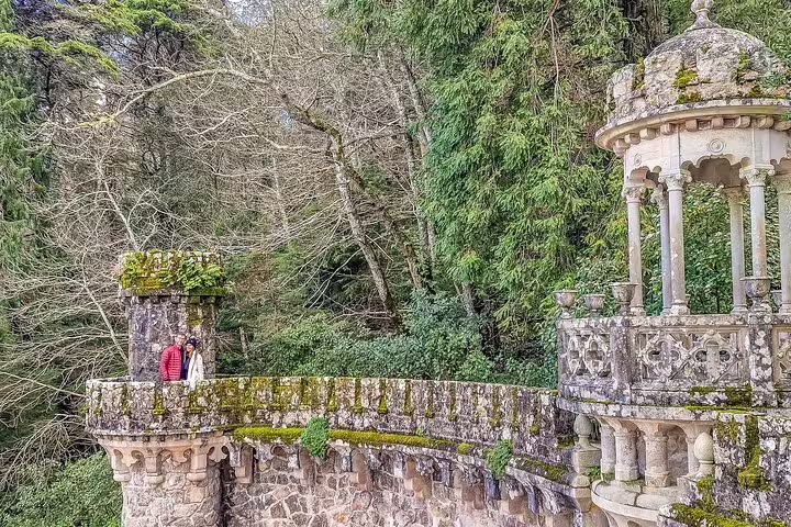 Couple exploring historic stone architecture and lush greenery on a private tour of Sintra's monuments from Lisbon.