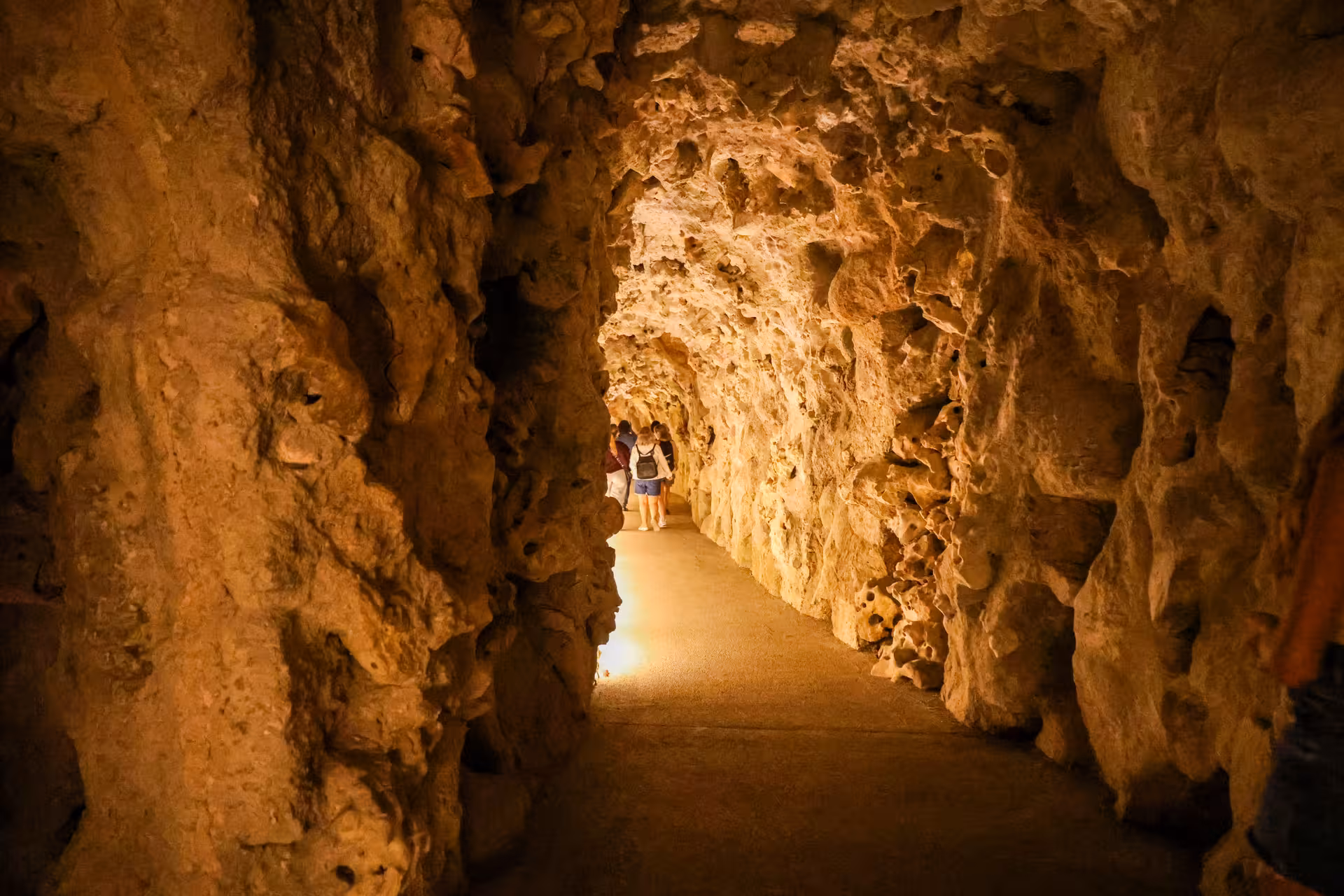 Visitors explore an illuminated cave tunnel at Quinta da Regaleira on a Sintra small group tour from Lisbon.