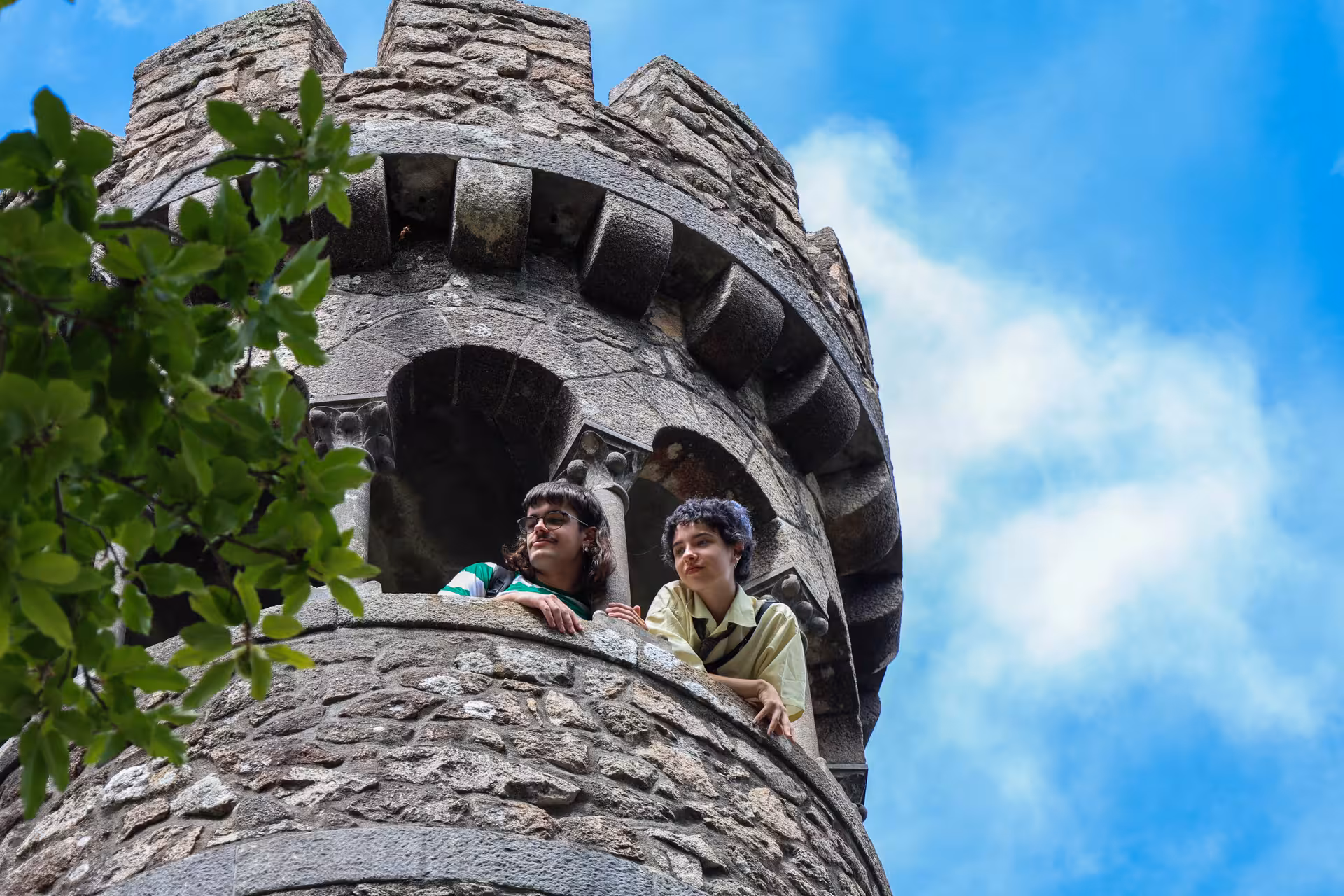 Visitors enjoy the view from a stone tower at Quinta da Regaleira, a must-see on the Sintra small group tour.