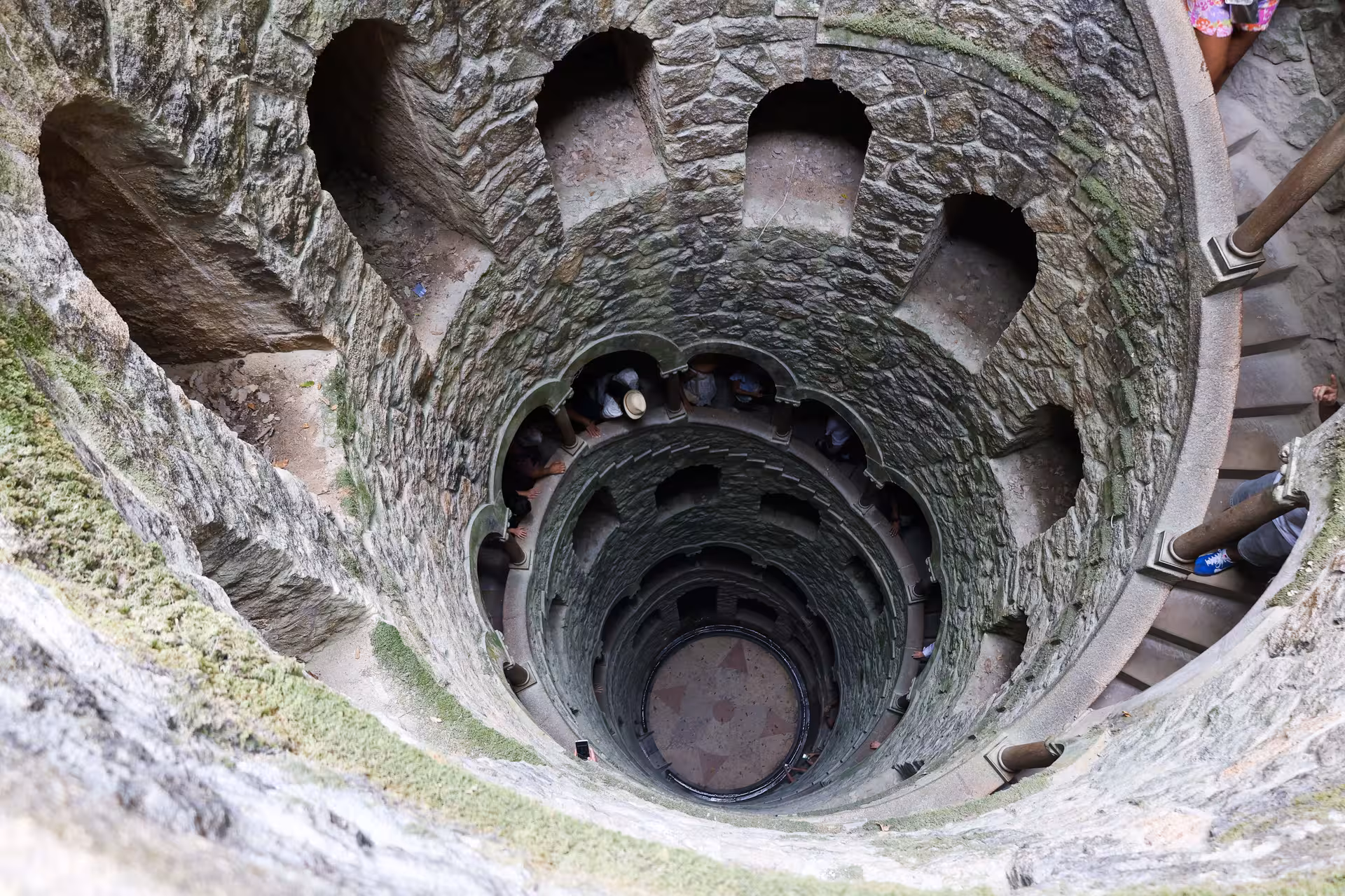 Looking down the mystical spiral staircase of Quinta da Regaleira in Sintra, a highlight of Lisbon tours.