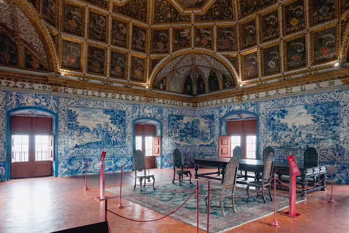 Ornate interior of Sintra's Regaleira Palace with intricate blue tiles, historic furniture, and detailed ceiling, featured on a private tour.