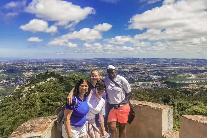 Group enjoying panoramic views on Sintra, Roca, and Cascais full-day private tour with Pena Palace tickets, under a bright sky.