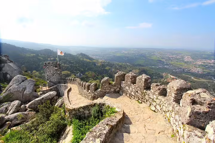 Scenic view from ancient stone walls in Sintra, showcasing lush landscapes on a Private Half-Day UNESCO Heritage Tour.