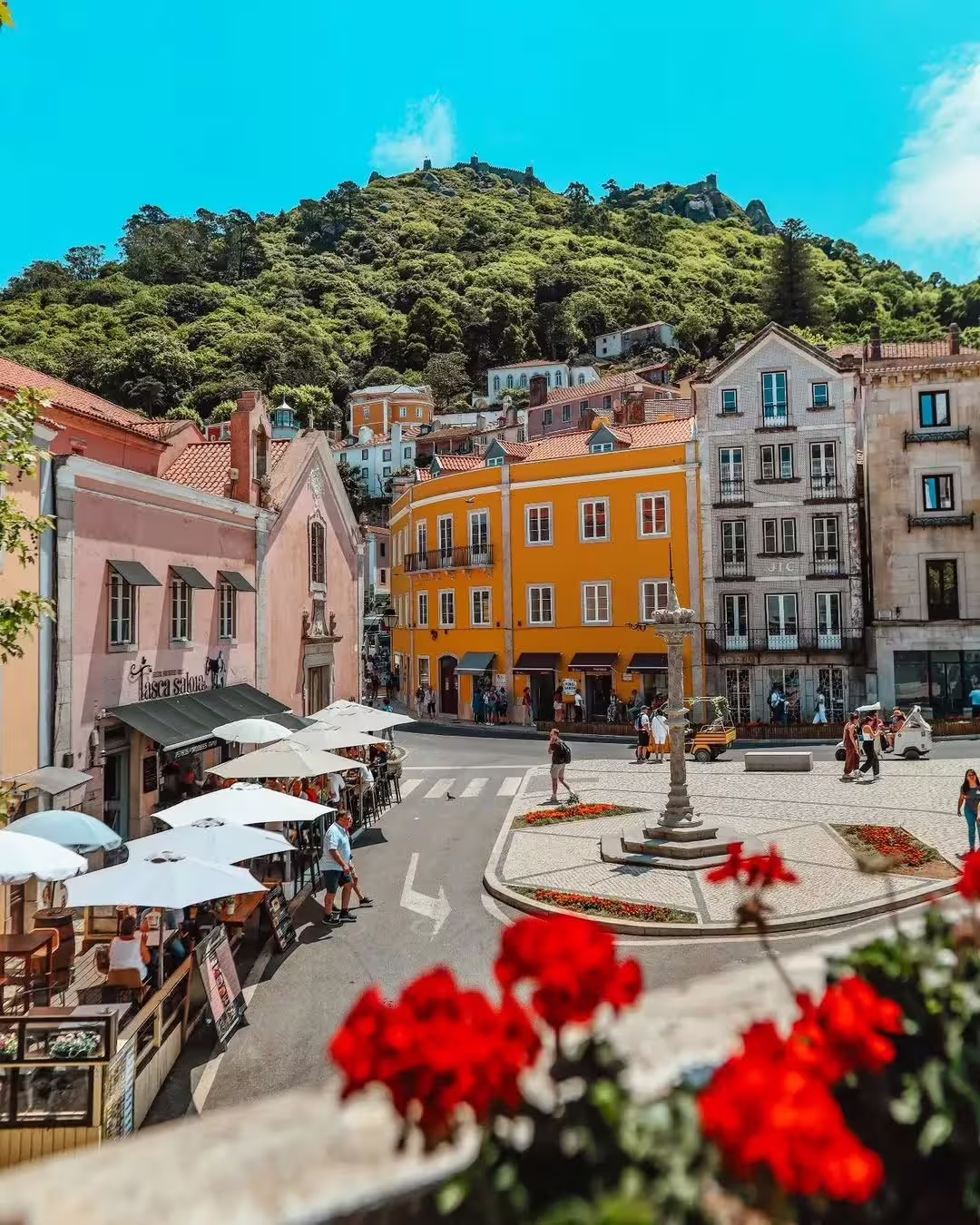 Charming Sintra town square with colorful buildings and lush hills, perfect for a half-day guided tour to Pena Palace.