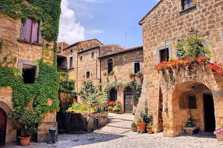 Charming cobblestone street in Sirmione with ivy-clad stone buildings and vibrant flowers, perfect for a day trip from Venice.