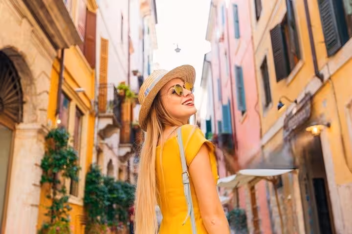 A traveler enjoys a sunny stroll through Sirmione's colorful streets on a private day trip from Venice.