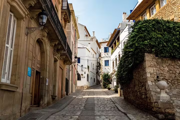 Charming narrow street in Sitges lined with historic architecture, ideal for exploring on a private tour.
