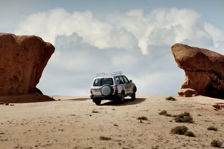 4x4 jeep driving between desert rock formations on a private 4-day Siwa Oasis tour from Cairo, Egypt