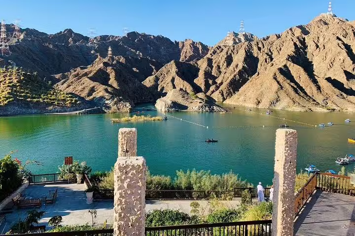 Picturesque view of a serene lake surrounded by mountains, showcasing natural beauty on the Six Emirates Tour.