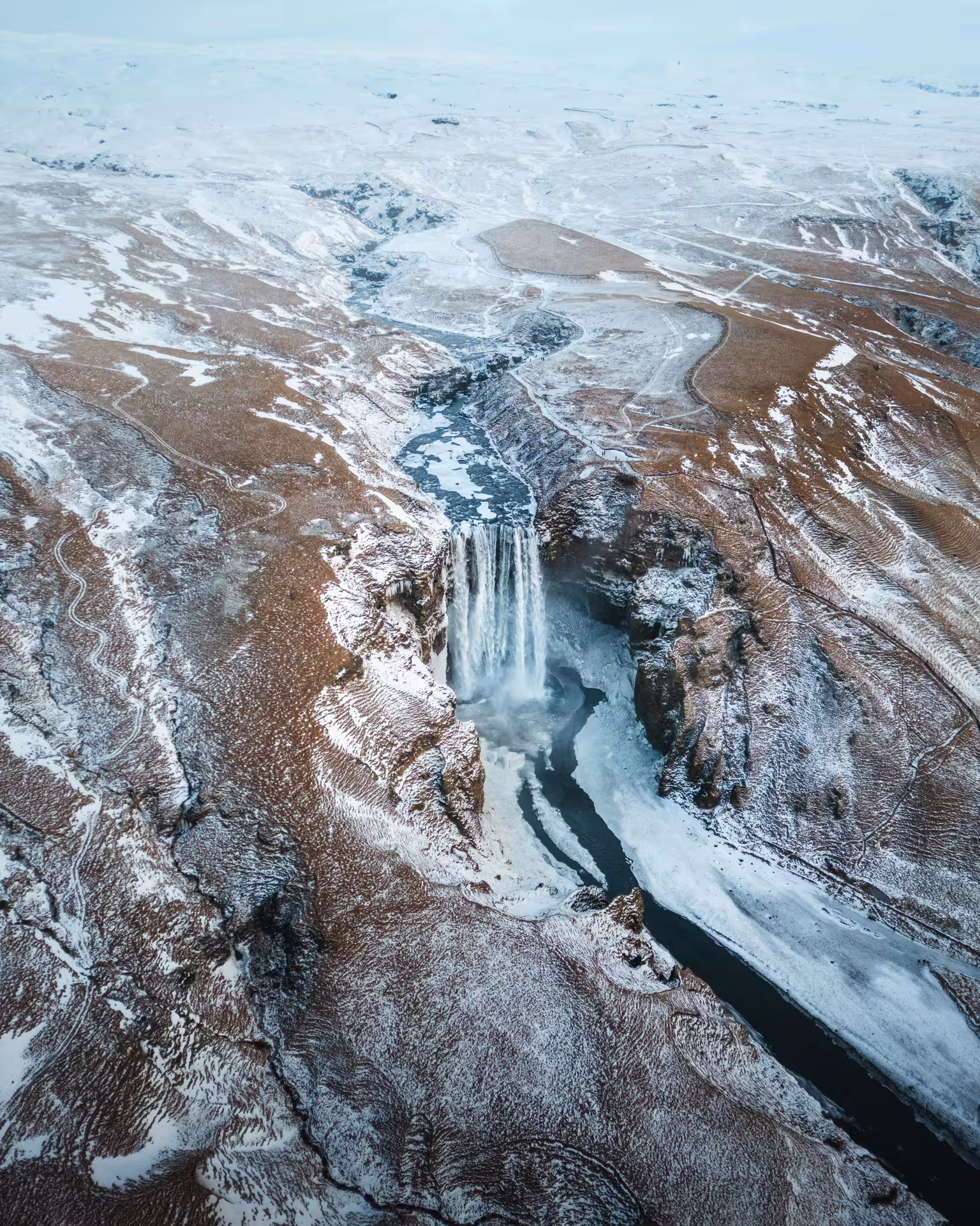 Aerial view of Skógafoss waterfall in winter on Iceland South Coast, scenic stop on Sólheimajökull hike tour
