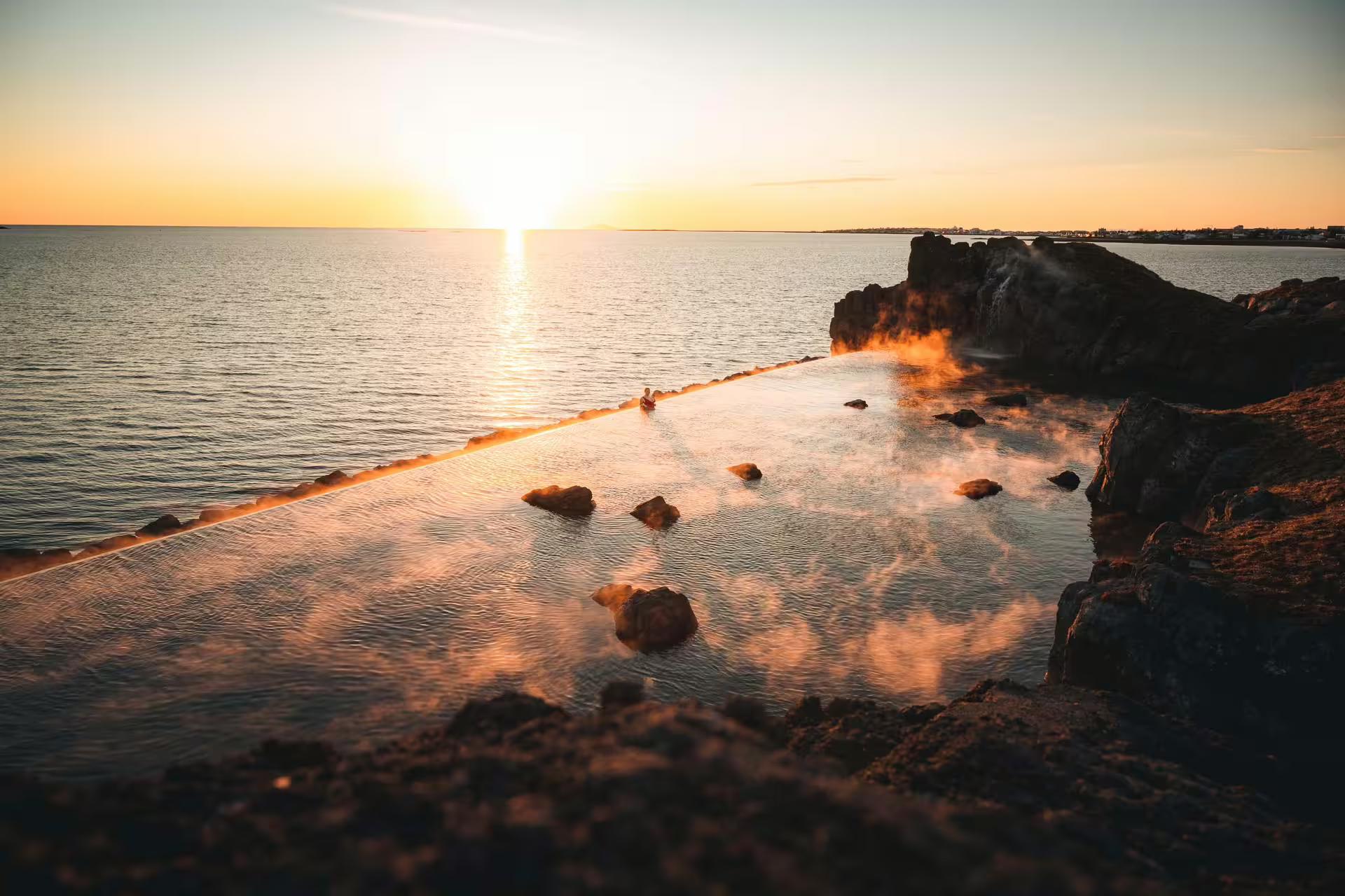 Stunning sunset view at Sky Lagoon with steaming geothermal waters, perfect for post-Silfra snorkeling relaxation in Iceland.