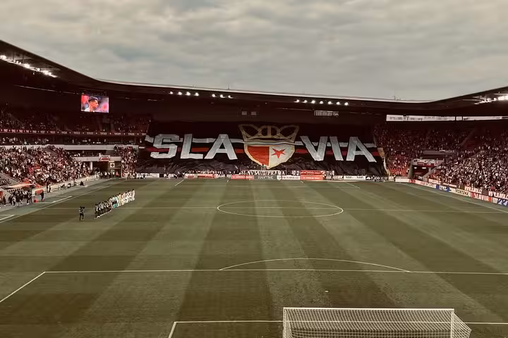 Packed Eden Arena with giant SLAVIA tifo before kickoff, part of Slavia or Sparta Prague game with a local tour