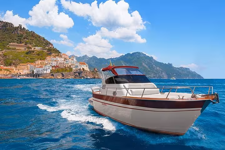 Speeding boat on the vibrant blue waters of the Amalfi Coast, showcasing exclusive small-group adventure opportunities.
